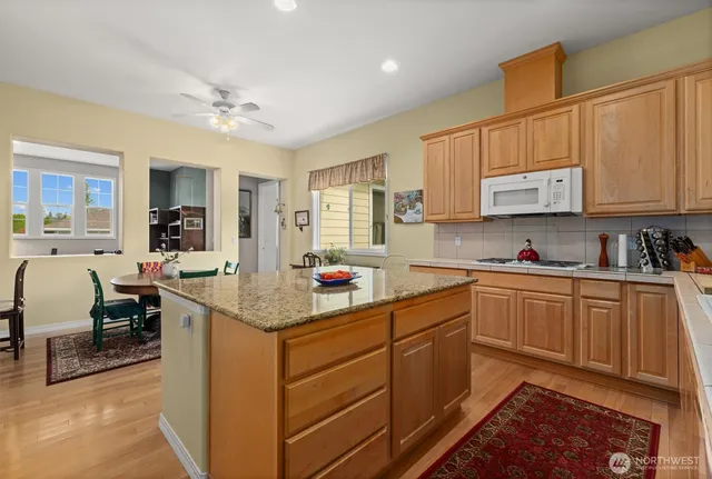 a kitchen with stainless steel appliances granite countertop a sink stove and cabinets