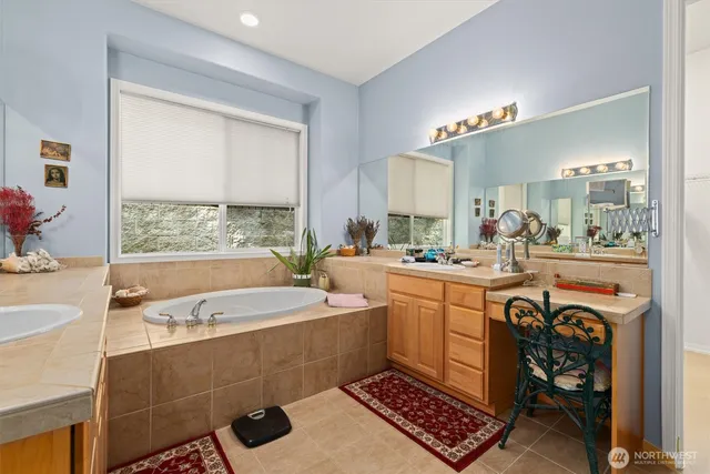 a large bathroom with a tub a sink and a window