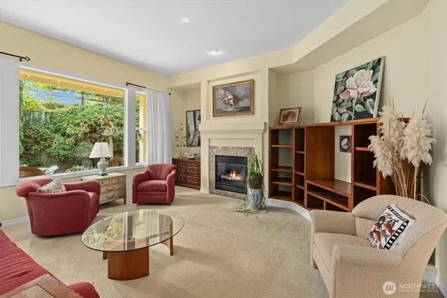 a living room with furniture a large window and a fireplace