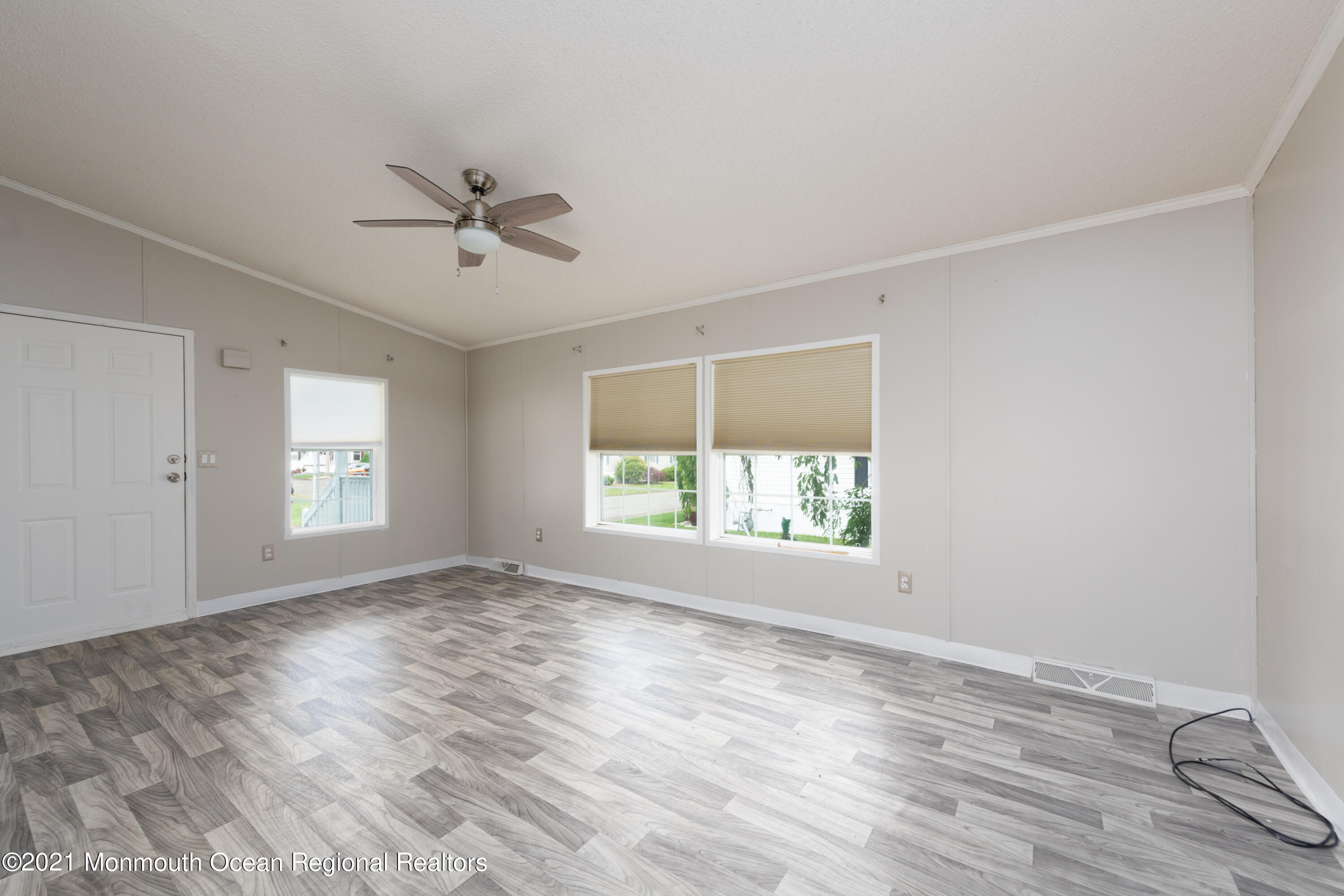 90 Village Road Morganville, NJ 07751 - Photo 3 of 25 a view of empty room with wooden floor and fan