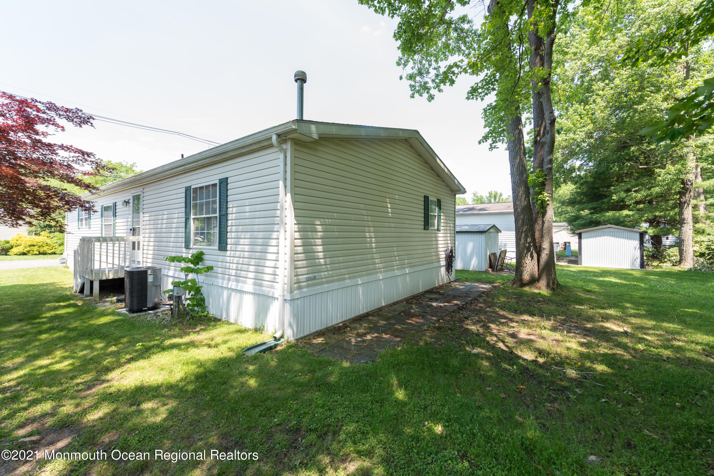 90 Village Road Morganville, NJ 07751 - Photo 23 of 25 a front view of house with yard and tree in it