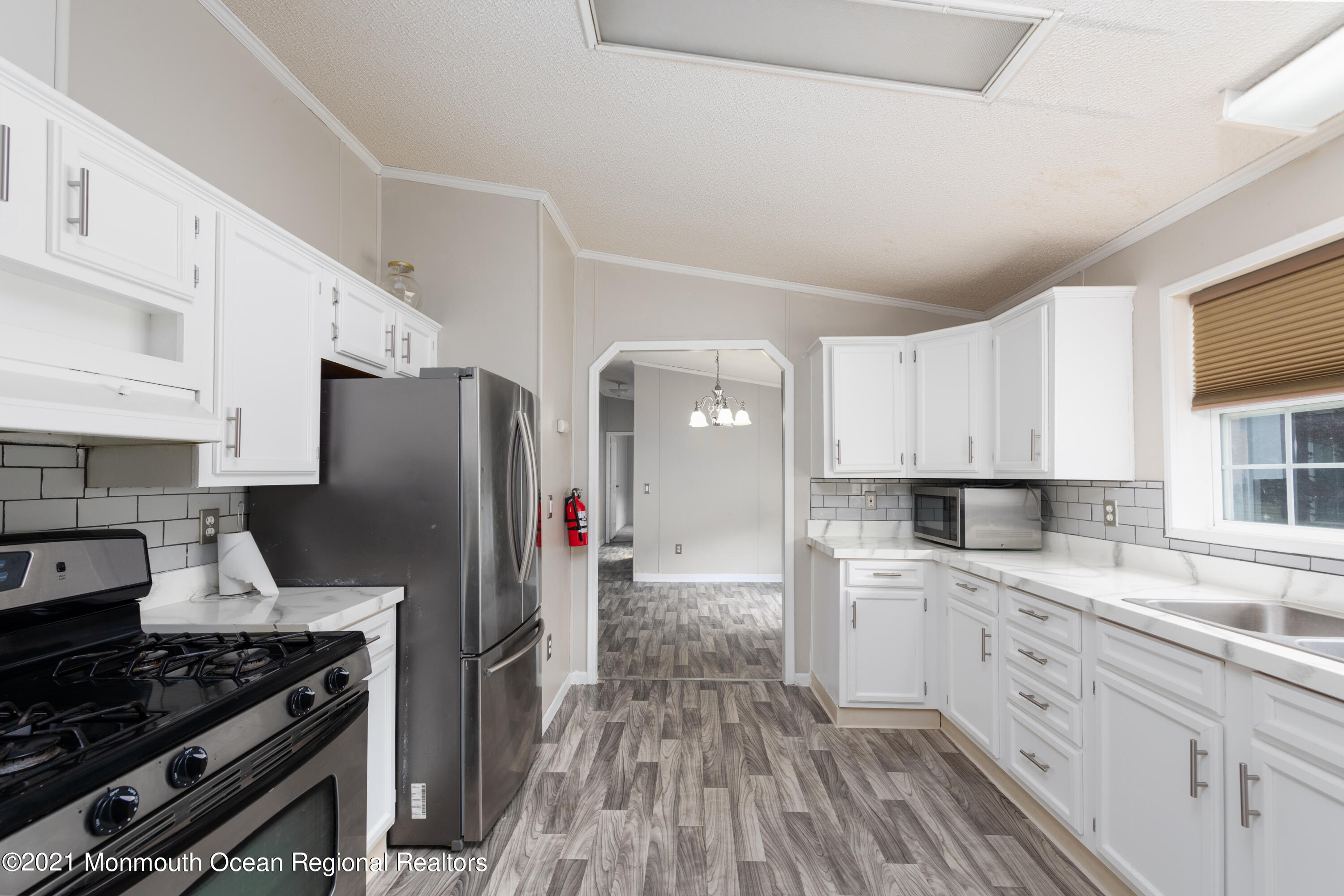 90 Village Road Morganville, NJ 07751 - Photo 6 of 25 a kitchen with a sink stove and refrigerator