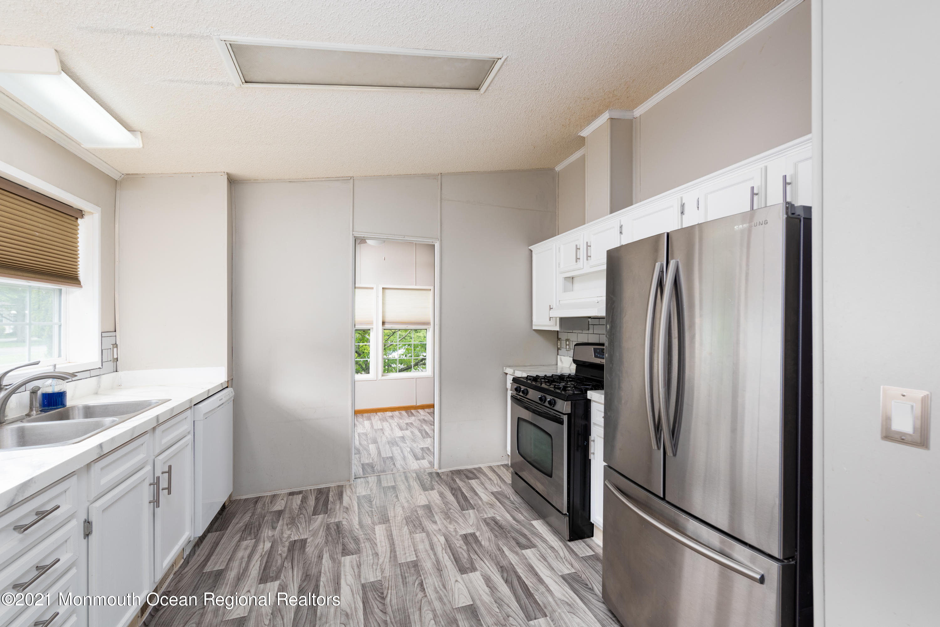 90 Village Road Morganville, NJ 07751 - Photo 7 of 25 a kitchen with a refrigerator and a sink