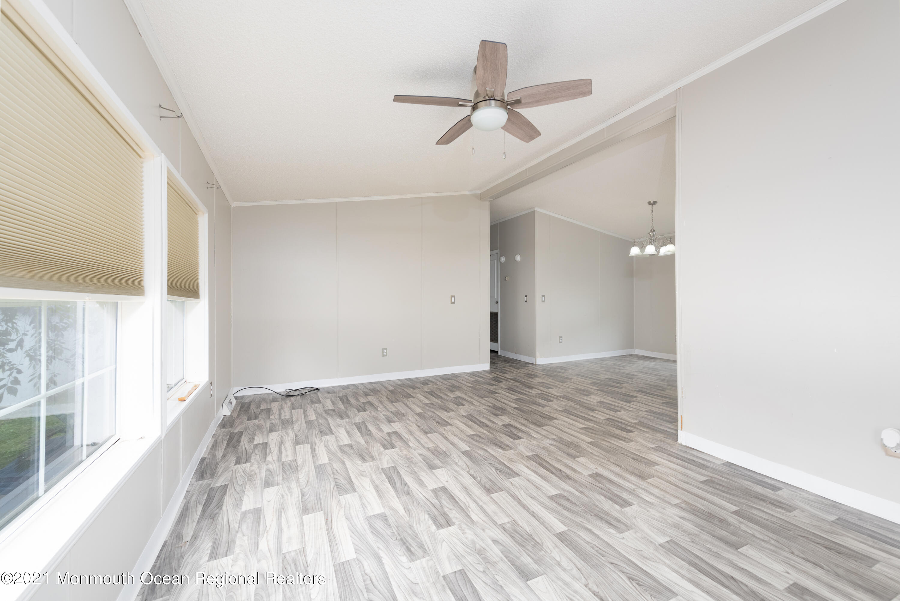 90 Village Road Morganville, NJ 07751 - Photo 9 of 25 a view of a livingroom with wooden floor and a ceiling fan