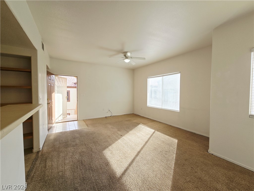 9580 West Reno Avenue, Unit 283 Las Vegas, NV 89148 - Photo 12 of 19 Unfurnished living room featuring a ceiling fan, carpet floors, and built in features
