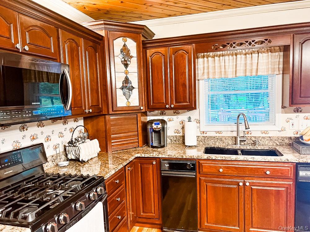 100 Old Tacy Road, Unit TR95 Bethel, NY 12783 - Photo 13 of 50 Kitchen featuring gas range oven, stainless steel microwave, light stone counters, ornamental molding, and dishwashing machine