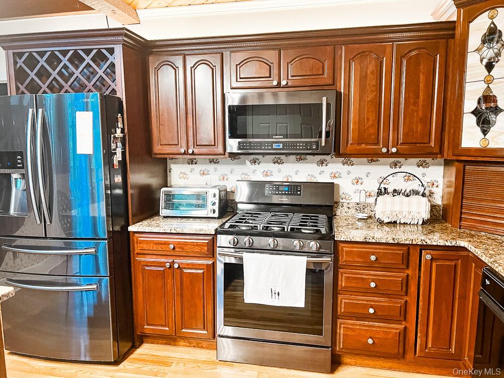 100 Old Tacy Road, Unit TR95 Bethel, NY 12783 - Photo 15 of 50 Kitchen with stainless steel appliances, light stone counters, and light wood finished floors
