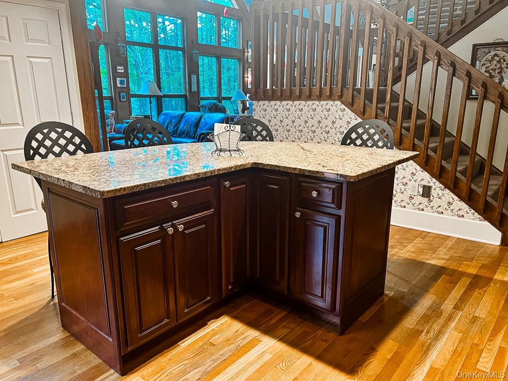 100 Old Tacy Road, Unit TR95 Bethel, NY 12783 - Photo 17 of 50 Kitchen with light wood-type flooring, light stone countertops, and dark brown cabinets