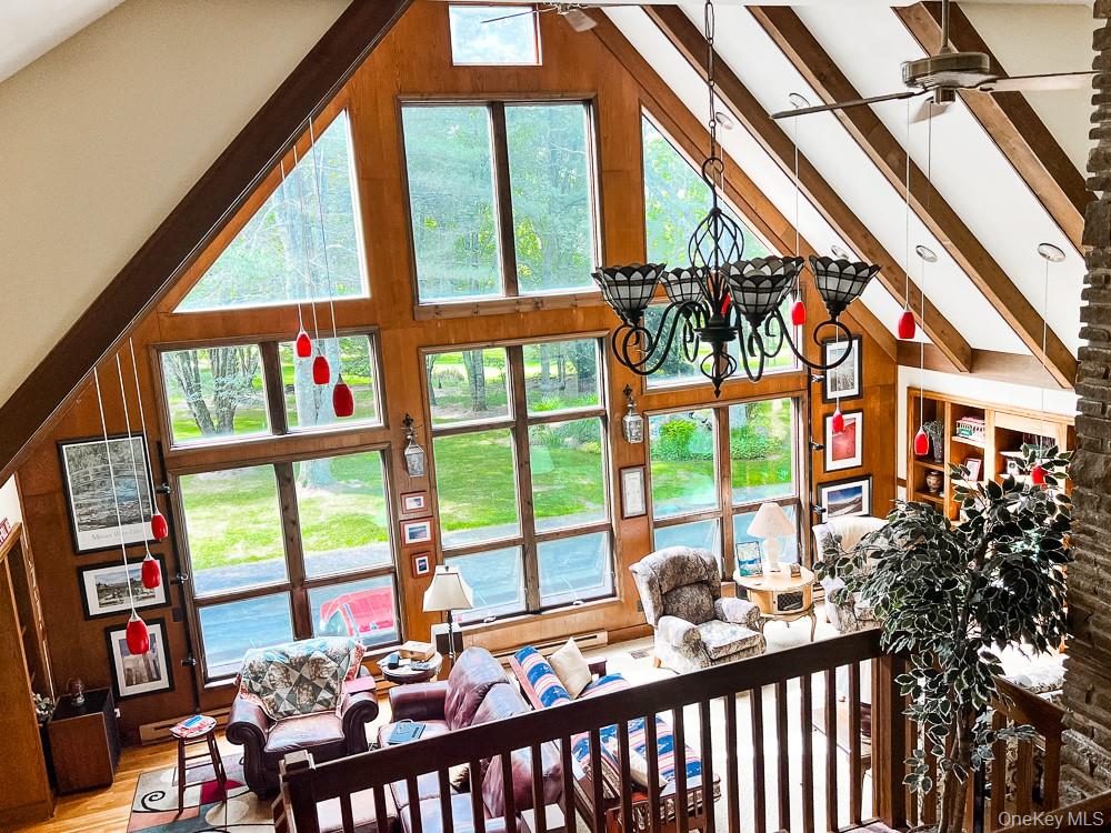 100 Old Tacy Road, Unit TR95 Bethel, NY 12783 - Photo 2 of 50 Living room featuring high vaulted ceiling, wood finished floors, plenty of natural light, ceiling fan, and beamed ceiling