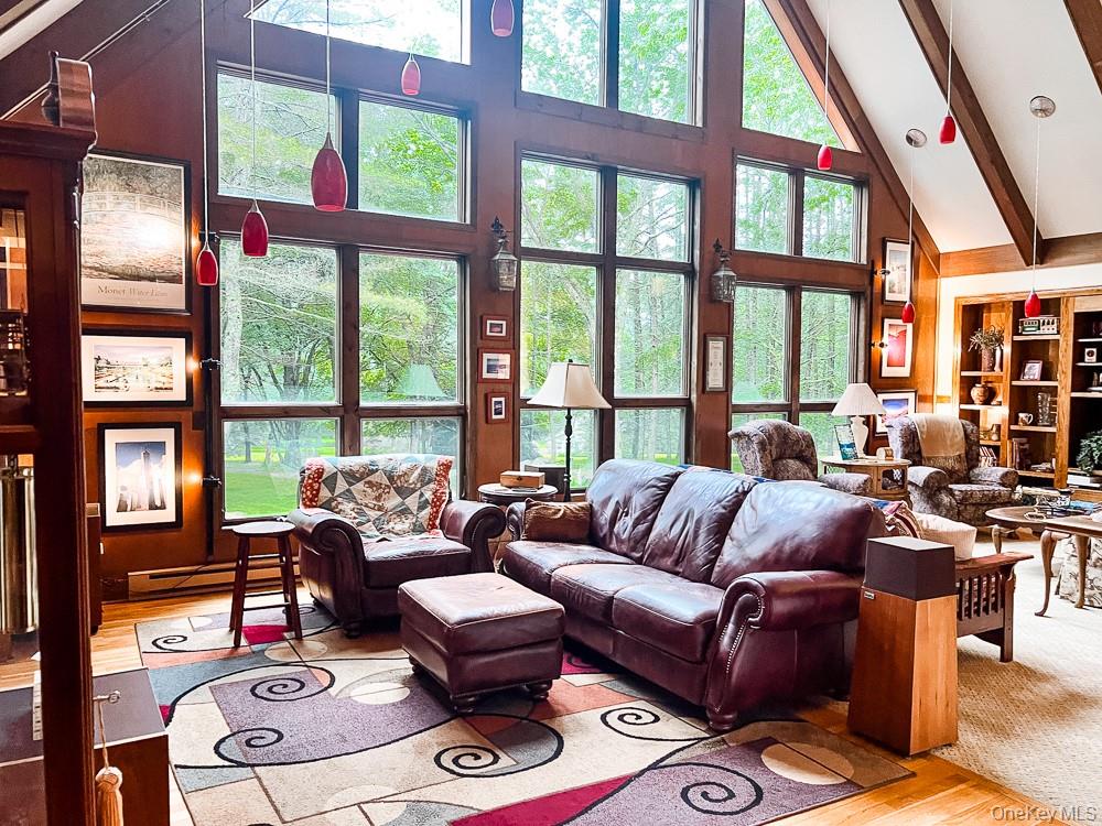 100 Old Tacy Road, Unit TR95 Bethel, NY 12783 - Photo 20 of 50 Living area featuring high vaulted ceiling, wood finished floors, beamed ceiling, and a baseboard heating unit