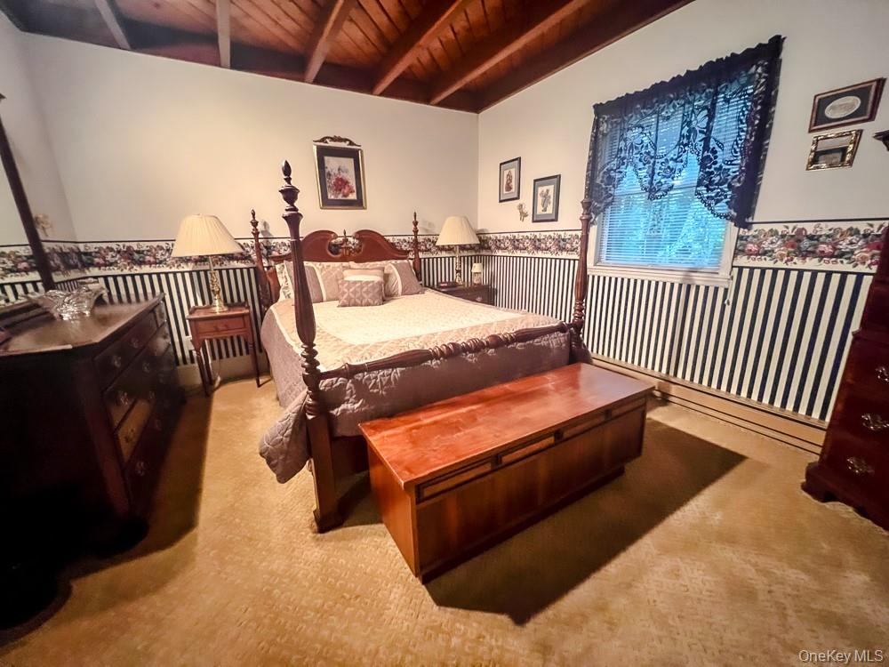 100 Old Tacy Road, Unit TR95 Bethel, NY 12783 - Photo 35 of 50 Bedroom with carpet, a wooden ceiling with exposed beams, and wainscoting