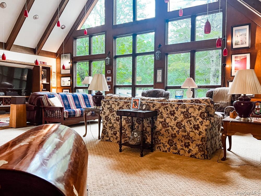 100 Old Tacy Road, Unit TR95 Bethel, NY 12783 - Photo 36 of 50 Living room featuring high vaulted ceiling, carpet flooring, beamed ceiling, and plenty of natural light