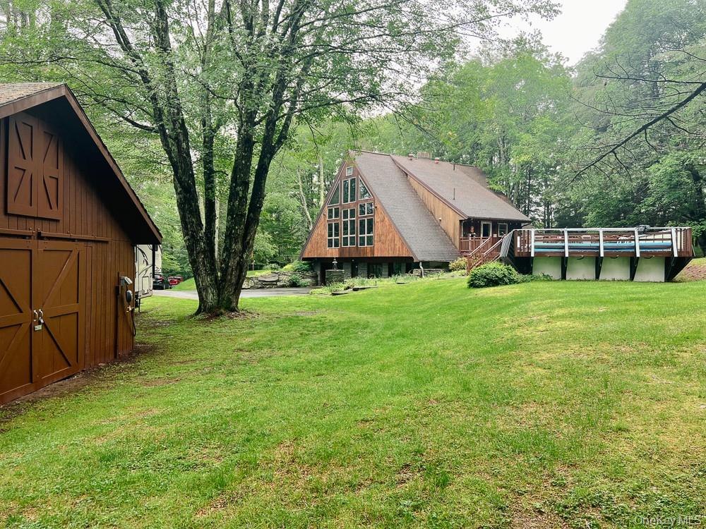 100 Old Tacy Road, Unit TR95 Bethel, NY 12783 - Photo 45 of 50 View of green lawn featuring an outbuilding, a barn, a deck, and an outdoor pool