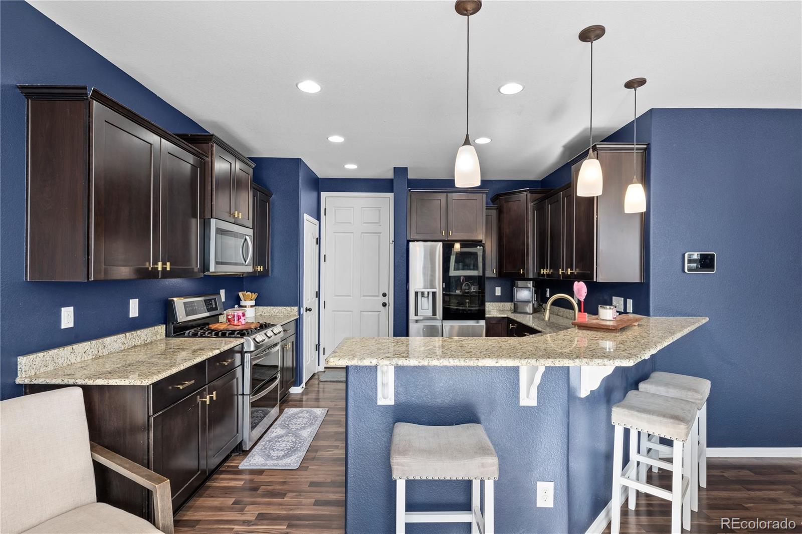 13826 West Layton Circle Morrison, CO 80465 - Photo 11 of 43 a kitchen with kitchen island granite countertop a sink a counter space appliances and cabinets