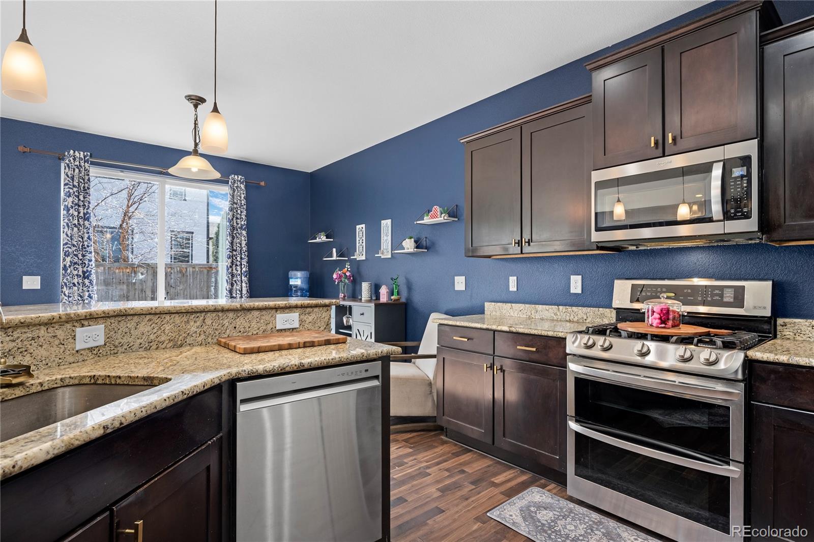 13826 West Layton Circle Morrison, CO 80465 - Photo 12 of 43 a kitchen with a stove microwave and cabinets