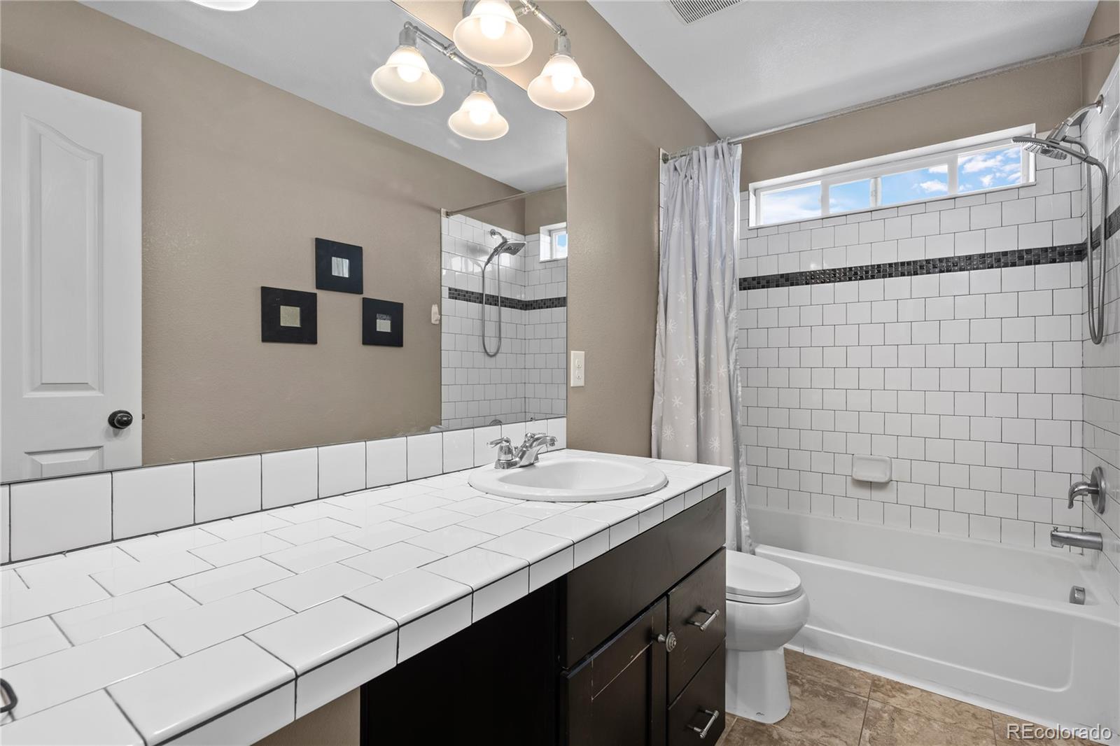 13826 West Layton Circle Morrison, CO 80465 - Photo 27 of 43 a bathroom with a sink a toilet and shower