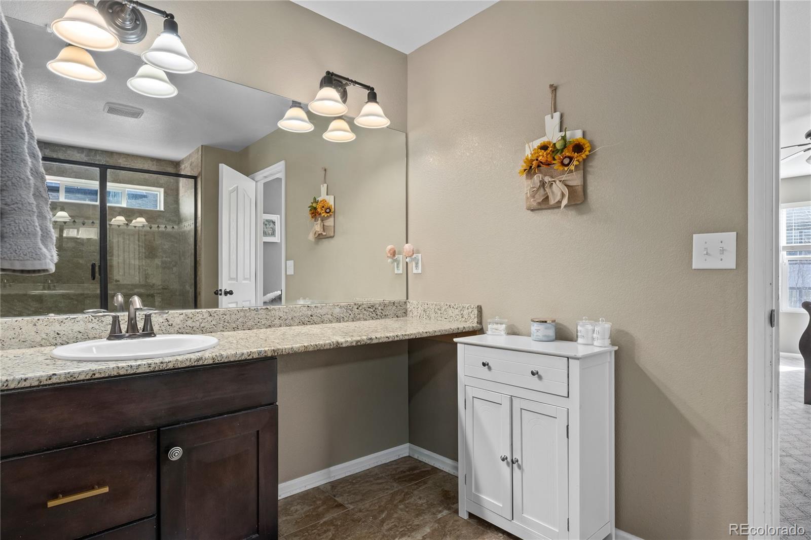 13826 West Layton Circle Morrison, CO 80465 - Photo 29 of 43 a bathroom with a sink a vanity and a mirror