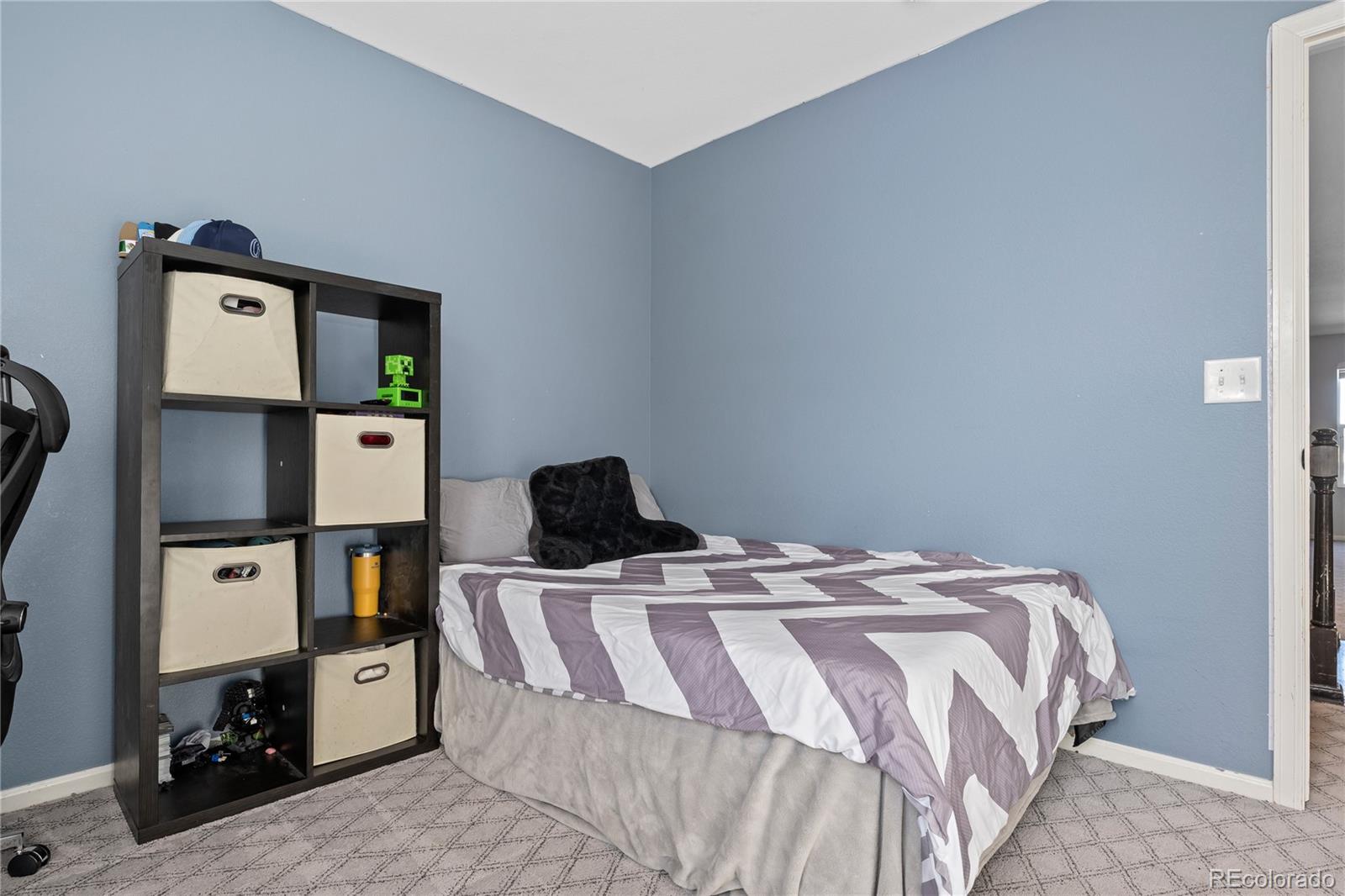 13826 West Layton Circle Morrison, CO 80465 - Photo 32 of 43 a bed sitting in a bedroom next to a window with tv