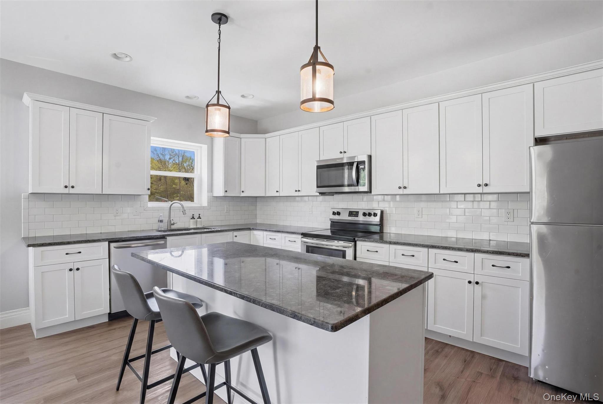 51 Redder Road Pine Bush, NY 12566 - Photo 20 of 29 a kitchen with kitchen island granite countertop a sink a center island and cabinets