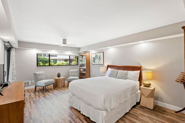 an aerial view of a house with yard and trees in the background