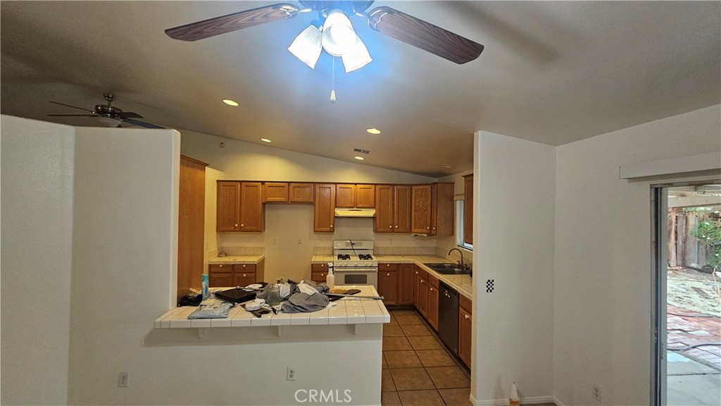 16528 Avenida Mirola Desert Hot Springs, CA 92240 - Photo 7 of 9 a kitchen with stainless steel appliances granite countertop a sink stove and refrigerator