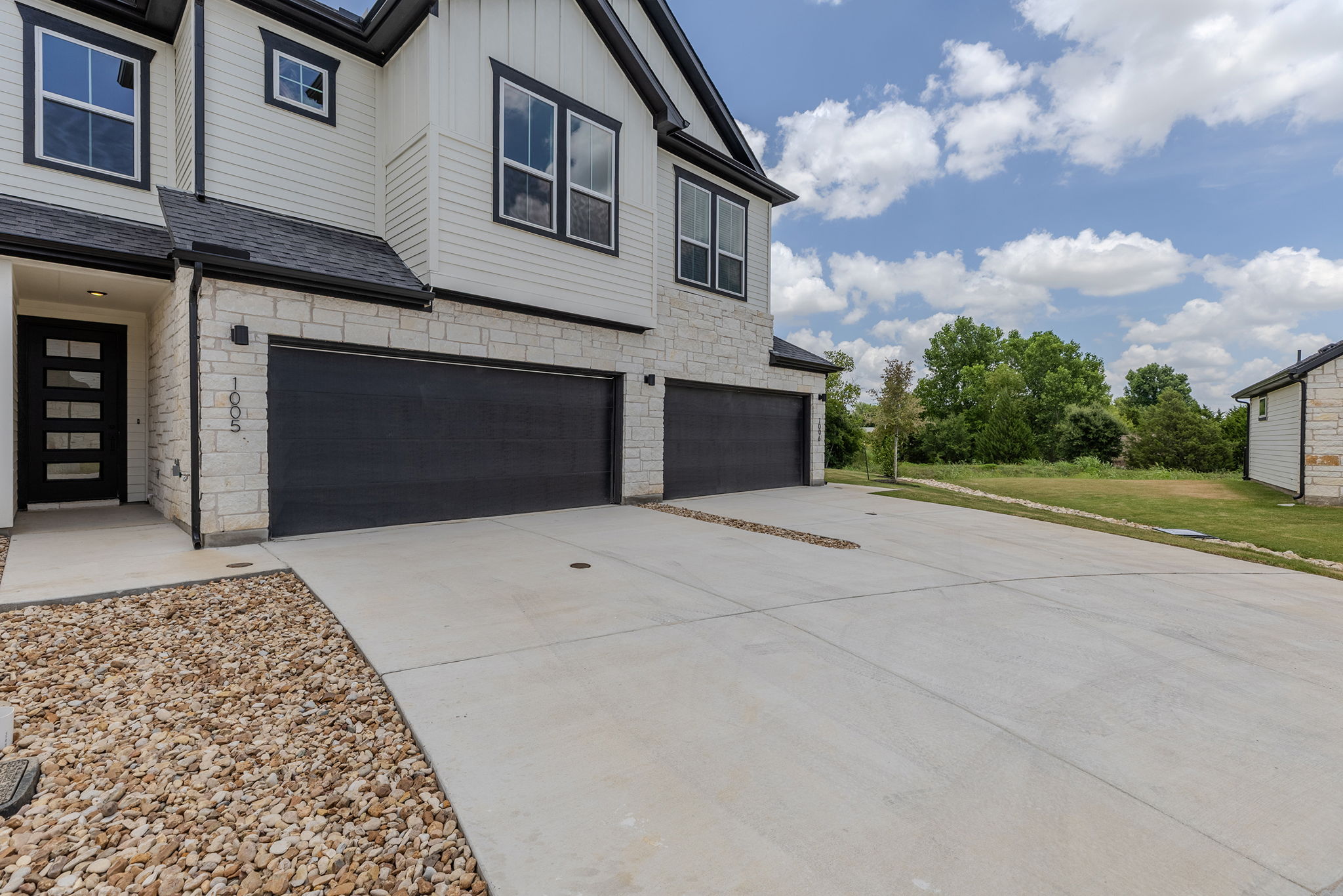 2600 Gattis School Road, Unit 1002 Round Rock, TX 78664 - Photo 37 of 40 A contemporary exterior showcasing a contrasting black and white palette with a spacious driveway.