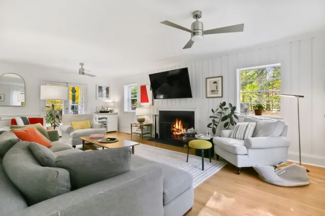 a living room with furniture a flat screen tv and a fireplace