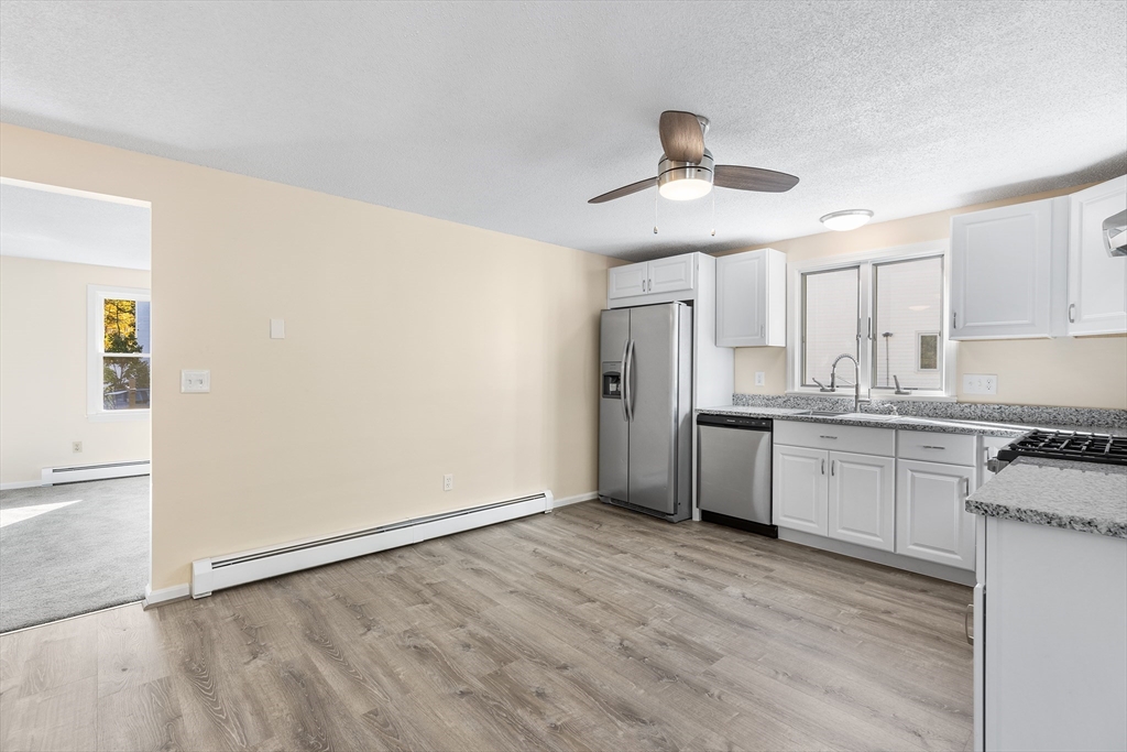 56 Vincent Circle Worcester, MA 01604 - Photo 3 of 23 a kitchen with granite countertop a refrigerator and a stove top oven