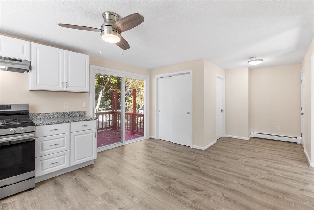 56 Vincent Circle Worcester, MA 01604 - Photo 5 of 23 a kitchen with granite countertop a stove a sink cabinets and wooden floor