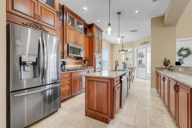 a kitchen with granite countertop white cabinets and stainless steel appliances