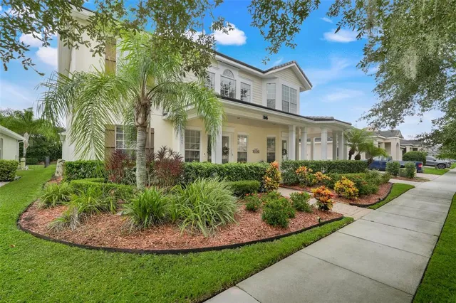 a view of a white house with a yard patio and a garden