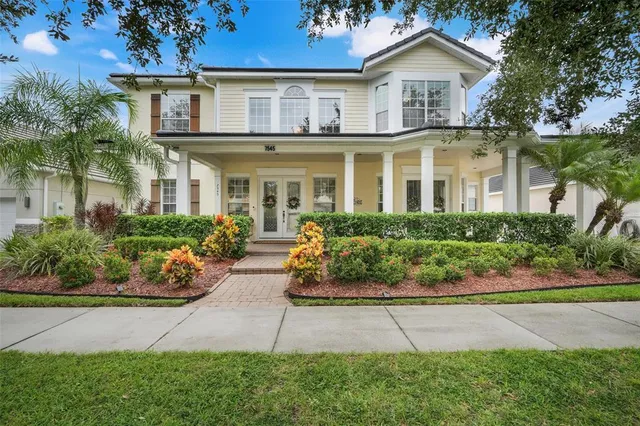 a front view of a house with a yard and potted plants