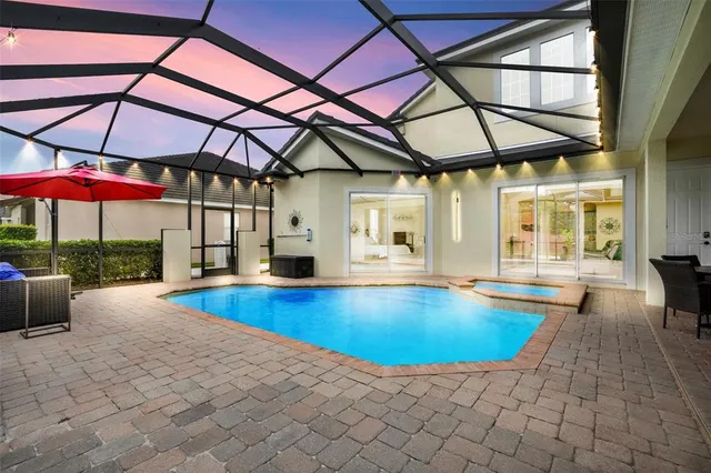 a view of a swimming pool with lawn chairs and a big yard