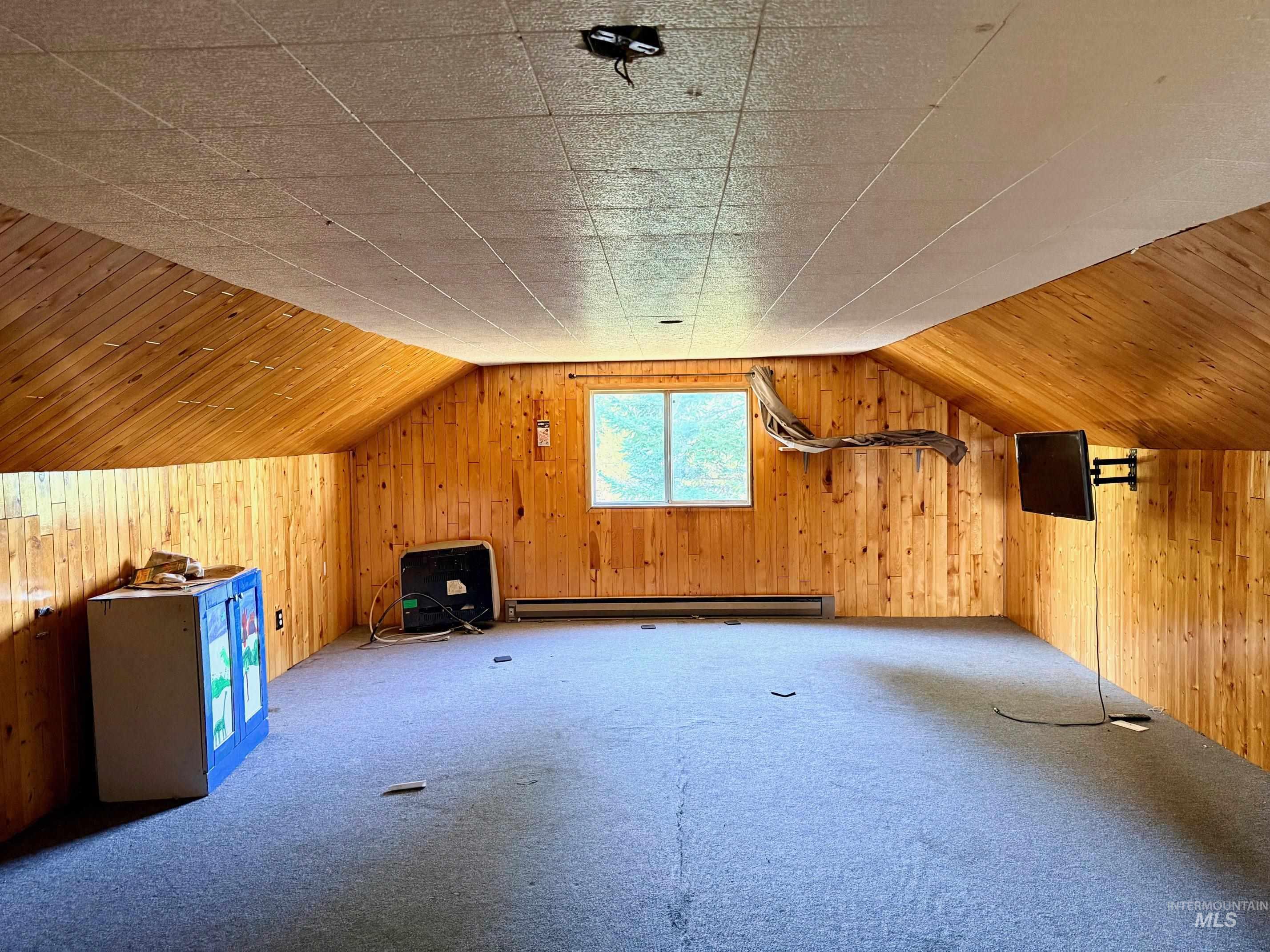 126 Aitken Road Weippe, ID 83553 - Photo 16 of 39 Spacious room featuring wood paneling on walls and sloped ceilings