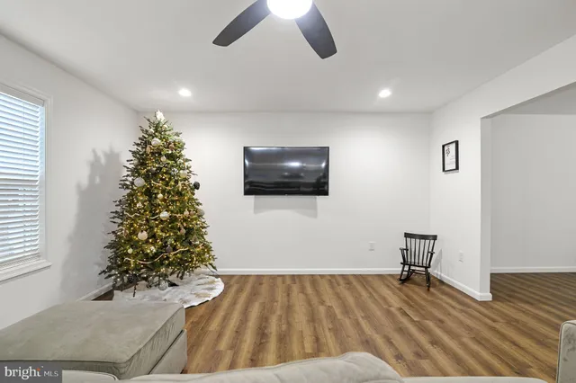 a view of a livingroom with wooden floor and a ceiling fan