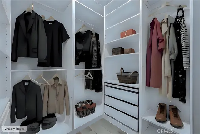 a view of walk in closet with clothes and shoes