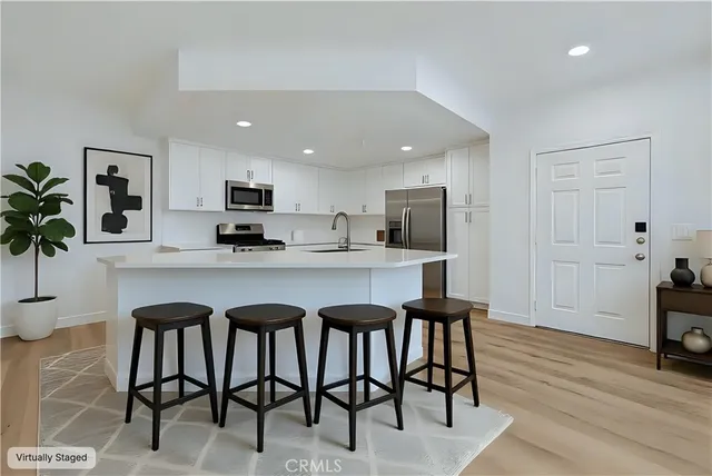 a kitchen with stainless steel appliances granite countertop table chairs sink and cabinets