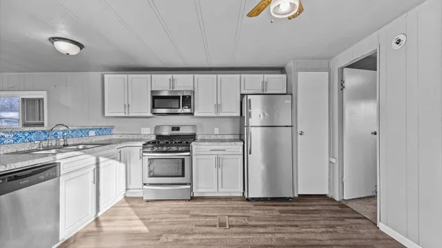 a kitchen with white cabinets and stainless steel appliances