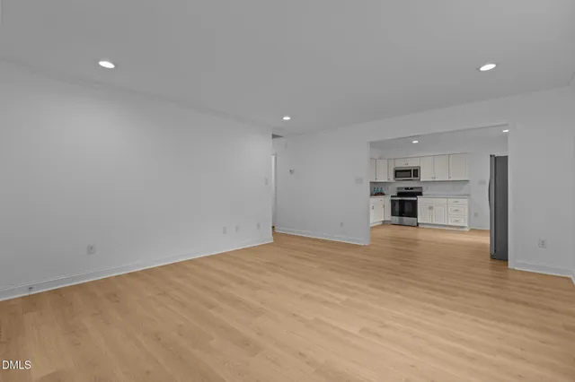 a view of empty room with wooden floor