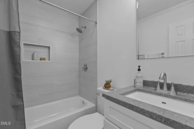 a bathroom with a granite countertop sink a toilet and bathtub