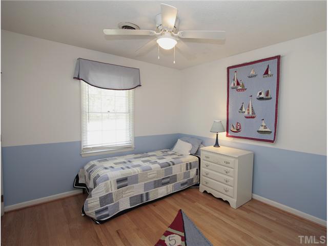 5404 Christman Court Raleigh, NC 27609 - Photo 12 of 20 a bedroom with a bed chandelier and a window