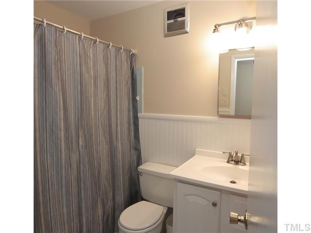 5404 Christman Court Raleigh, NC 27609 - Photo 15 of 20 a bathroom with a sink a toilet and shower curtain