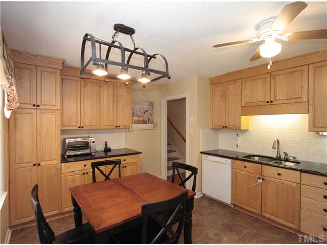 5404 Christman Court Raleigh, NC 27609 - Photo 6 of 20 a kitchen with stainless steel appliances granite countertop a sink a stove a table and chairs