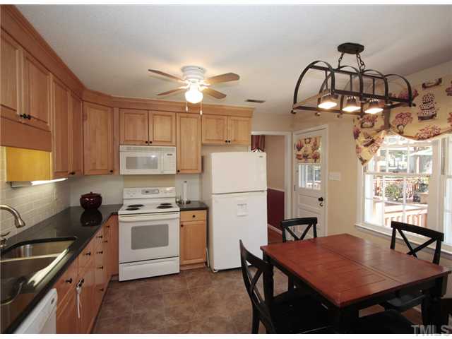 5404 Christman Court Raleigh, NC 27609 - Photo 8 of 20 a kitchen with cabinets appliances and a chandelier