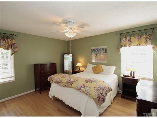 5404 Christman Court Raleigh, NC 27609 - Photo 10 of 20 a bedroom with a bed and a chandelier