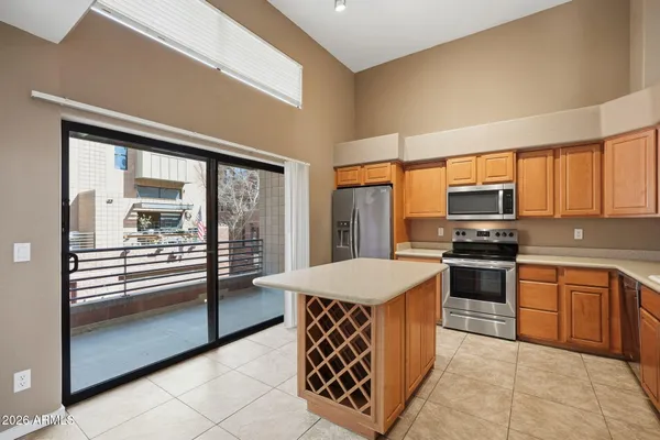 a kitchen with stainless steel appliances granite countertop a stove top oven a sink and a refrigerator