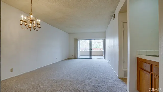 a view of an empty room with a kitchen