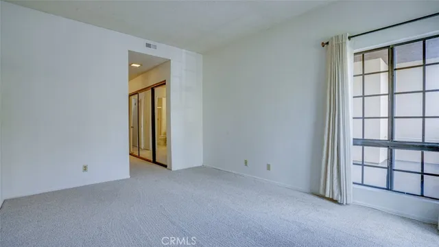 a view of a swimming pool with a yard and palm trees