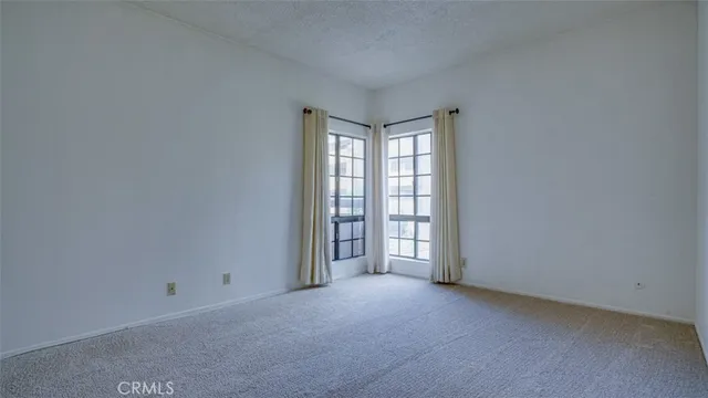 a view of swimming pool on a sunny day with lawn chairs and plants