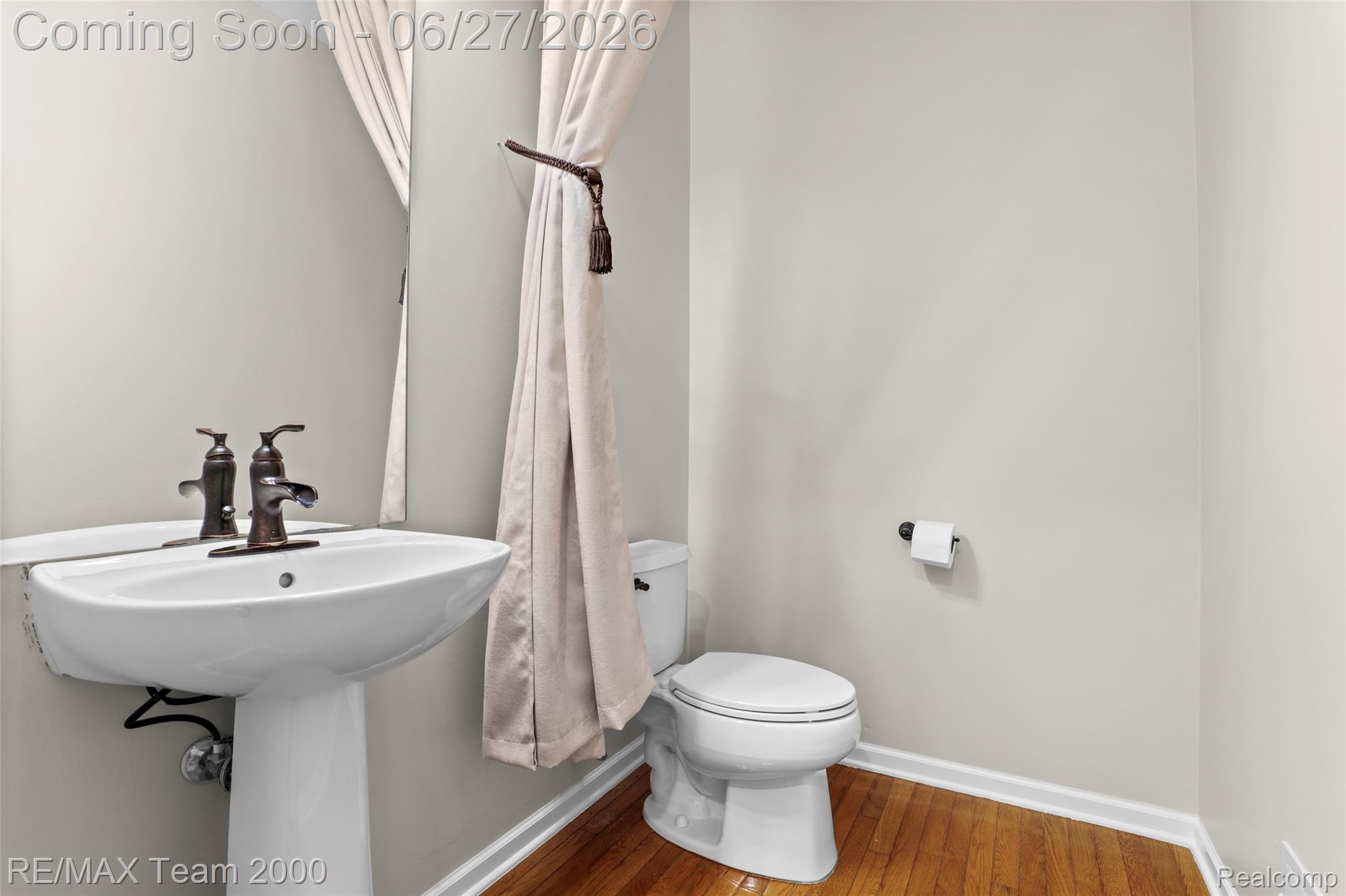1248 Lasalle Road Canton, MI 48187 - Photo 42 of 67 Pedestal sink with bronze-finish faucet, framed mirror, and wood-finish flooring